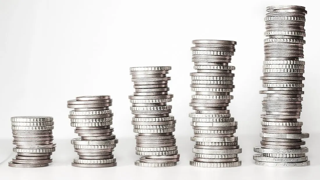 Five stacks of coins rising in height from left to right against a white background.